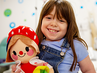 Young patient holding a lotsy dotsy hospital clown dolll